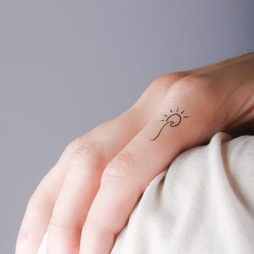 tatouage ephemere vague soleil porte sur le doigt style minimaliste et boheme