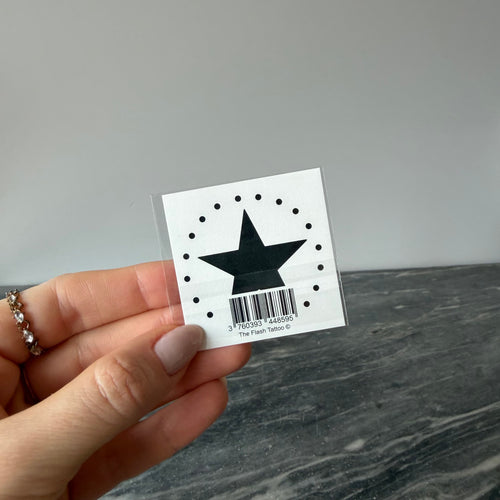 Tatouage éphémère étoile noire avec points autour